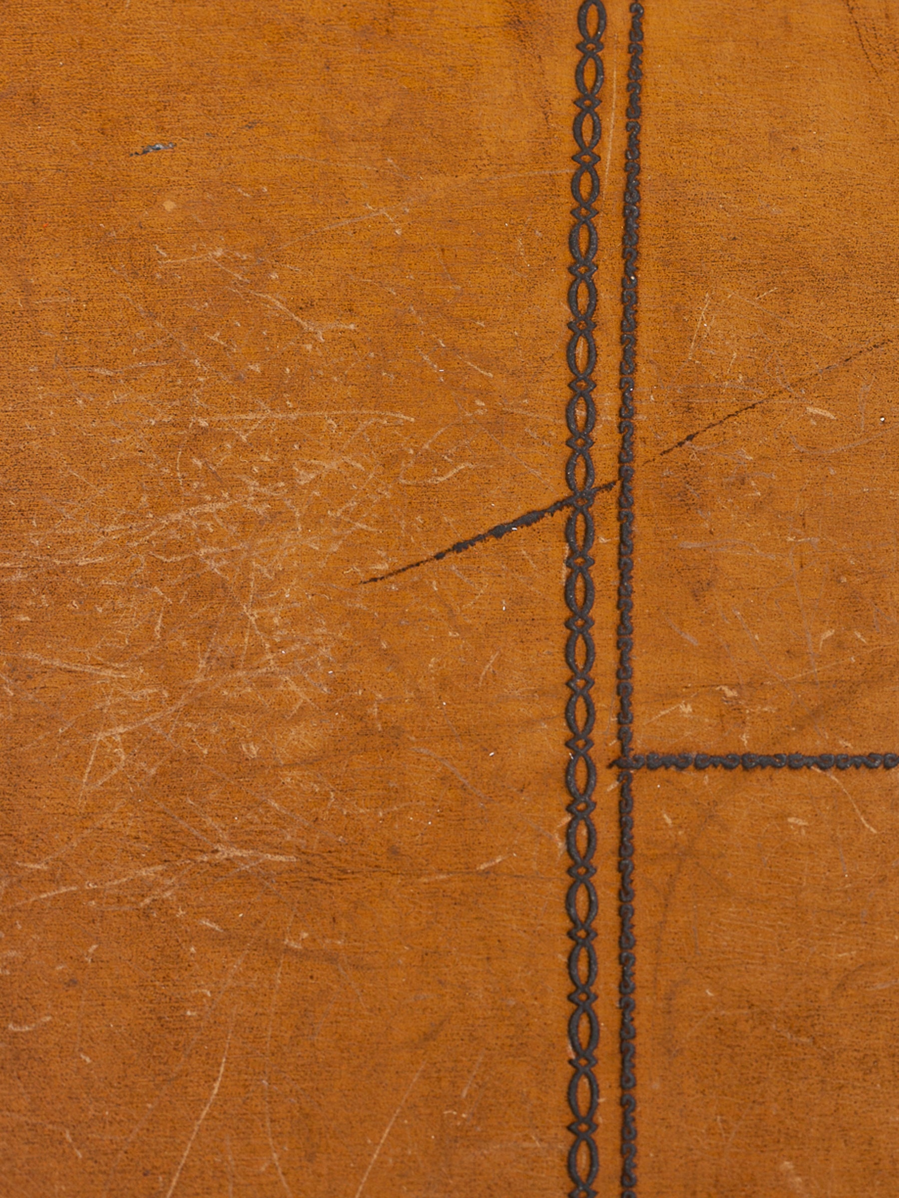 Close-up of a textured olive leather surface with a dark stitched vertical and horizontal line pattern.