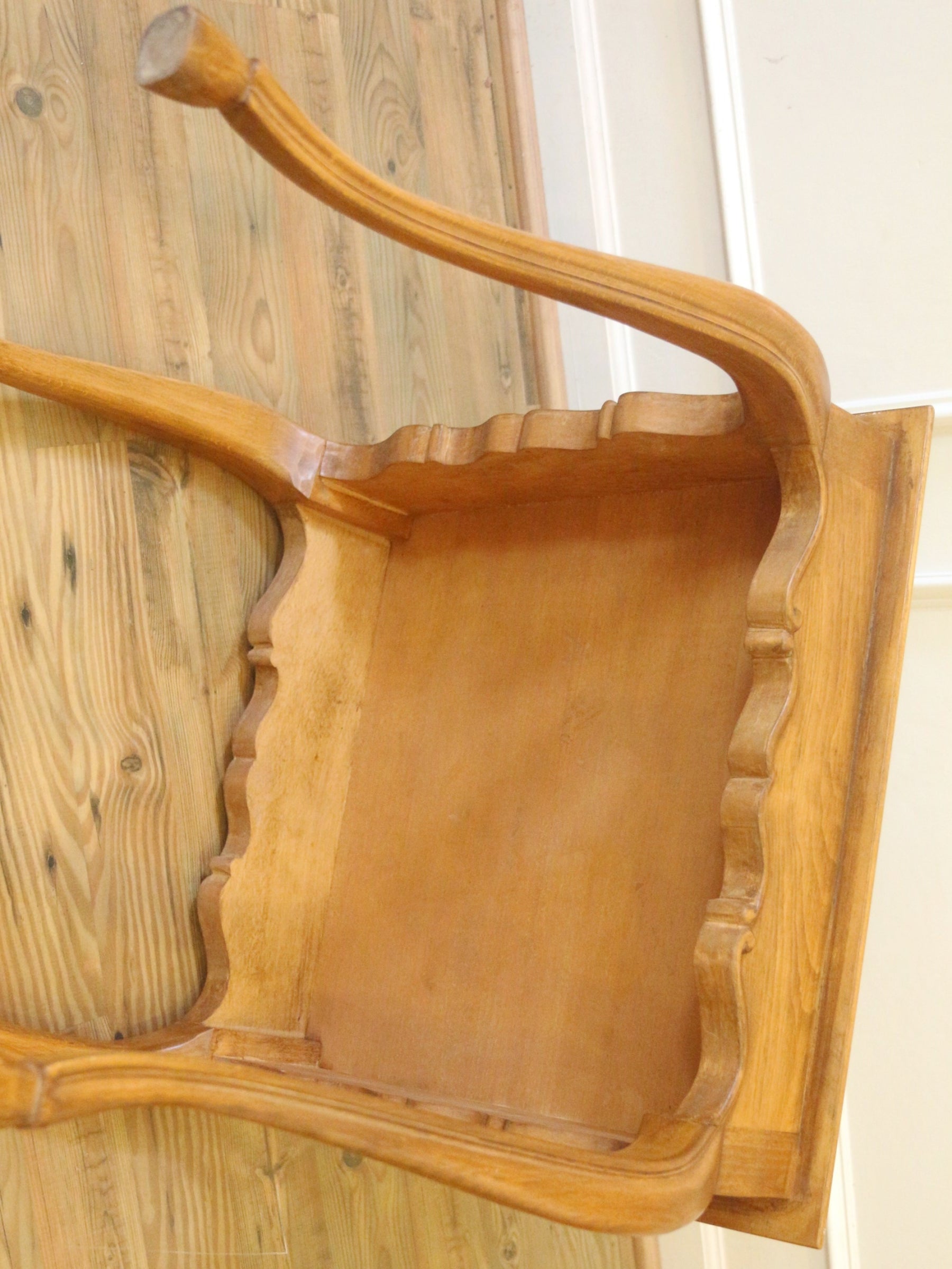 The clean under side of small square cherry wood table with cabriolet legs and hoof feet.
