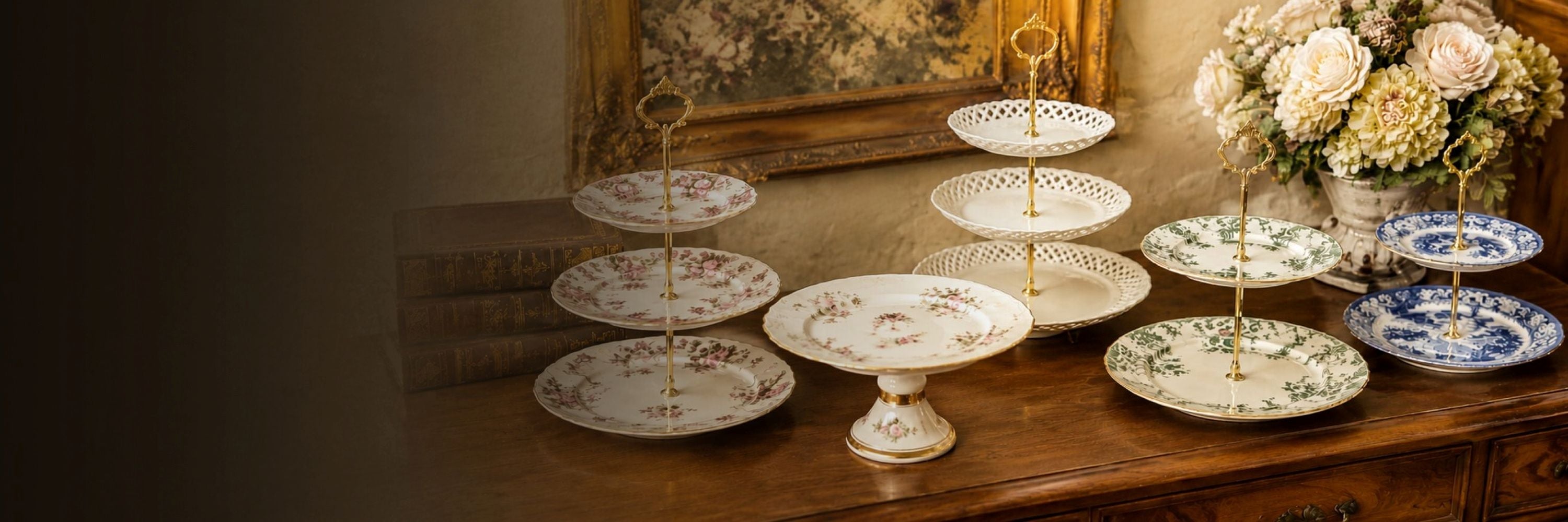 Collection of antique porcelain cake stands and tiered serving plates displayed on a wooden sideboard.